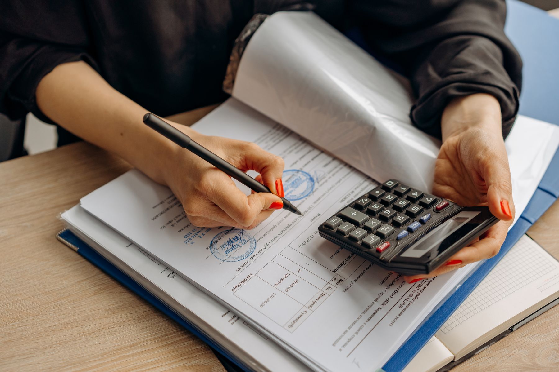 Tax paperwork, calculator, and notes on a desk during accounting review