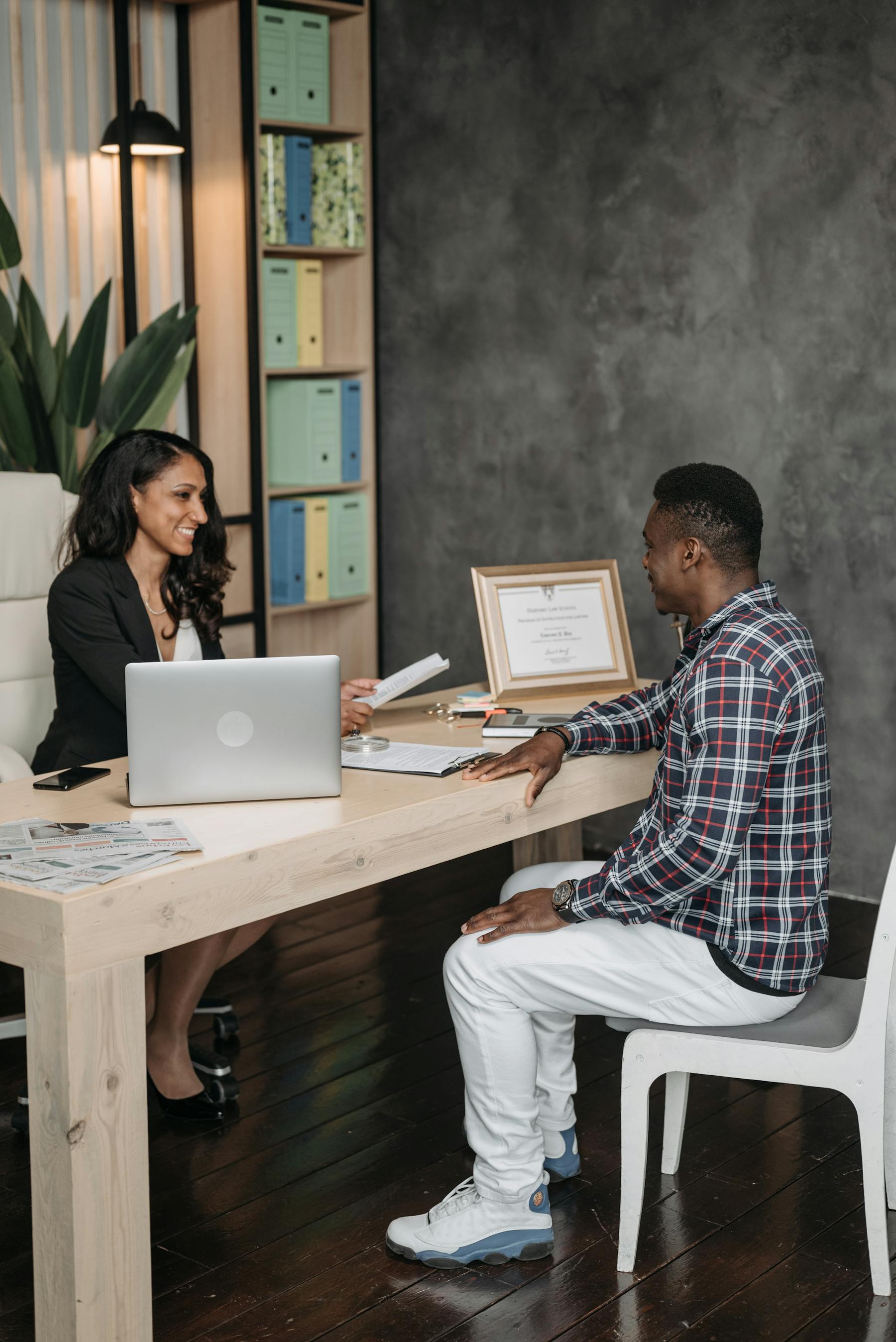 Lawyer speaking with a client across a desk in a small office
