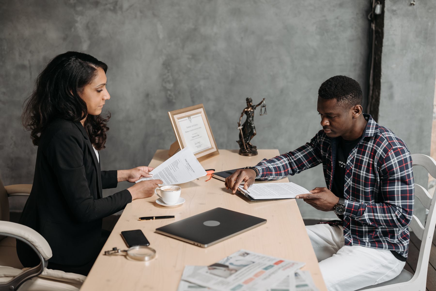 Legal documents and a laptop arranged on a conference table
