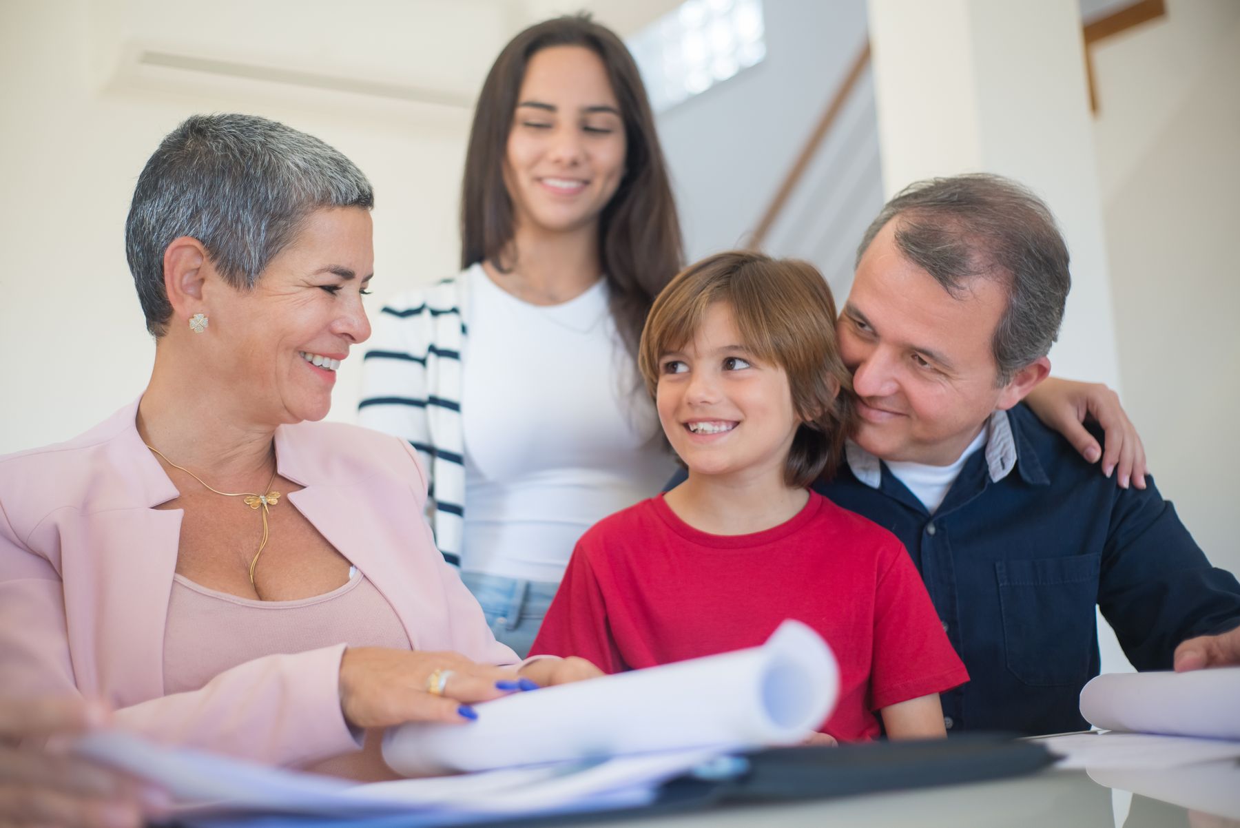 Family smiling with a real estate agent while holding house keys